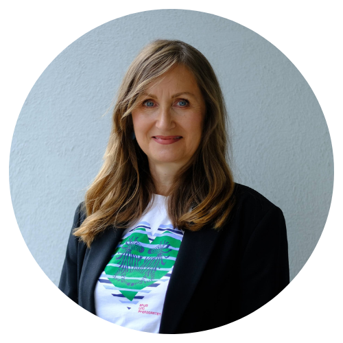 Frau Karola Rossmy mit einem legeren dunklen Blazer im Halbprofil lächelnd in die Kamera.